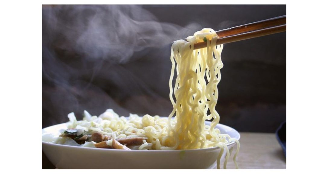 chopsticks picking up a steaming helping of ramen noodles