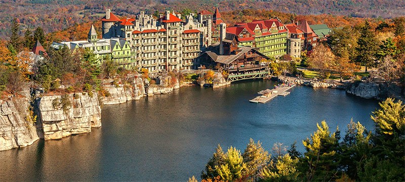 An aerial view of Mohonk Mountain House on cliffs overlooking the lake