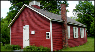 old red schoolhouse with red brick chimney