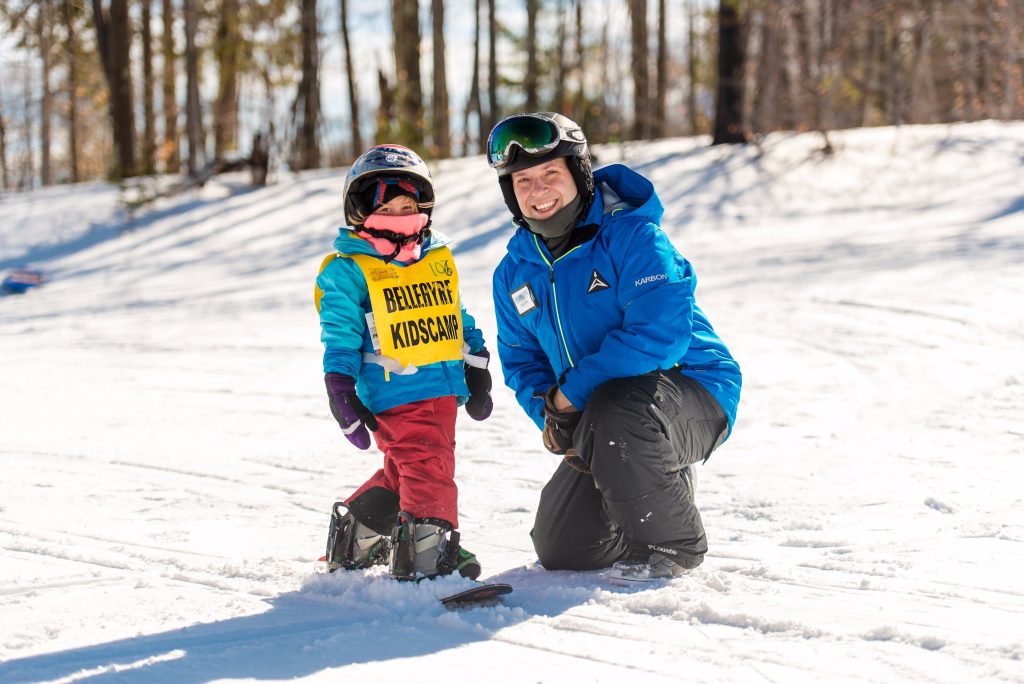 Instructor and kid snowboarding