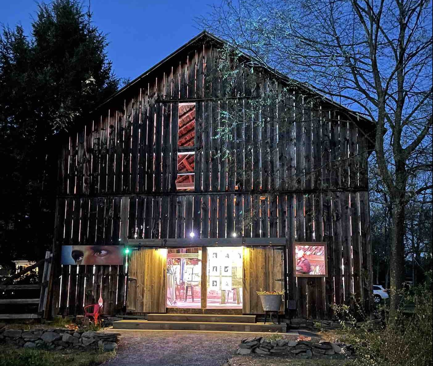 exterior of barn with open doors showing artwork displays