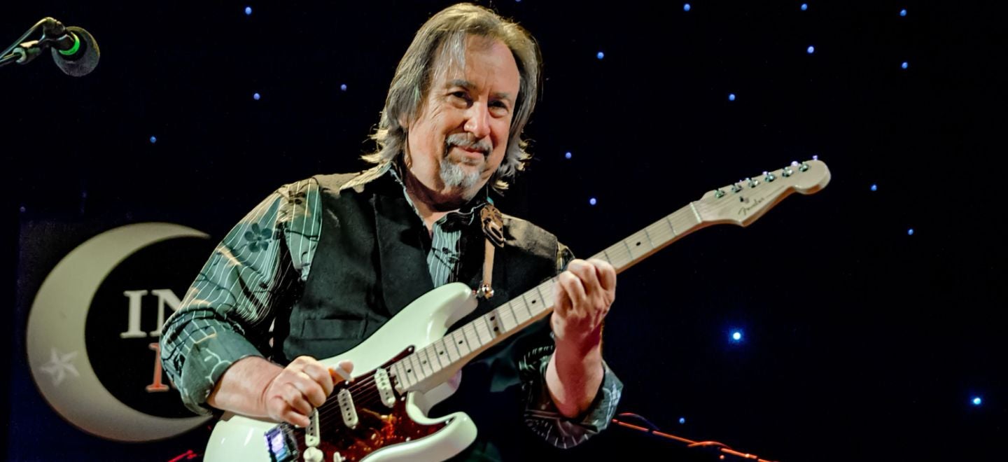 Jim Messina playing his guitar on stage