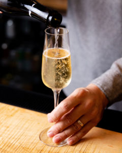 man pouring a glass of white wine