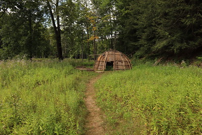 path in a green field leading to a wigwam