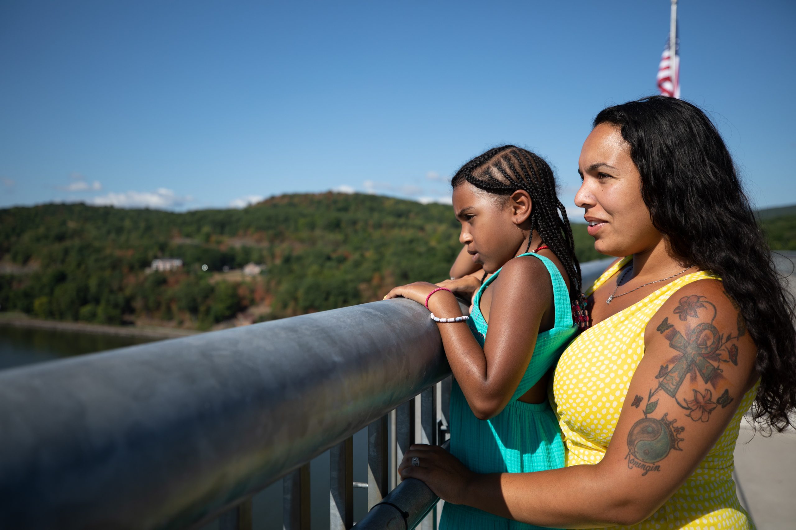 mom and daughter looking over the river from a lookout point