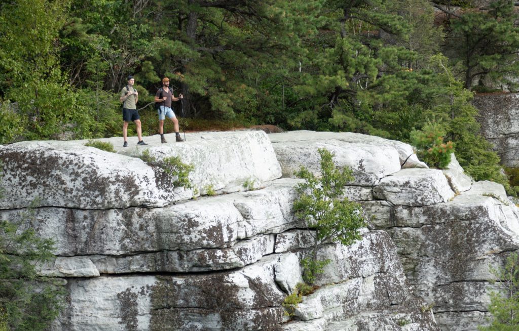 men standing on a white cliff in hiking gear