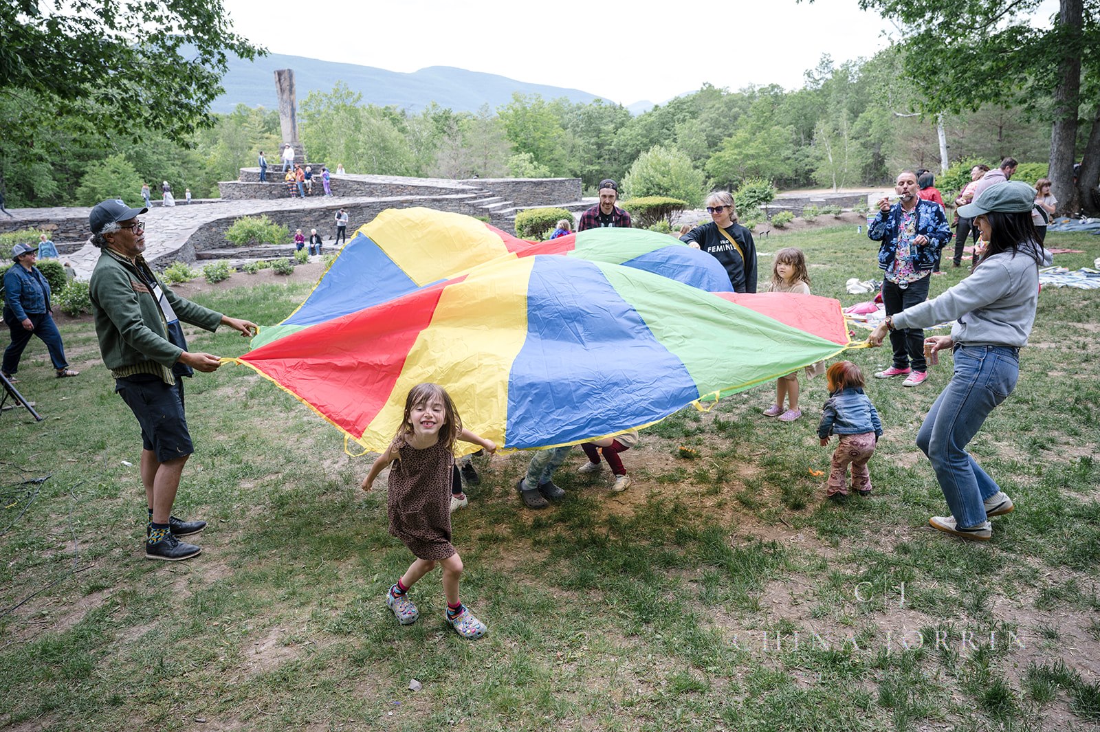 kids playing in a field with a colorful parachute