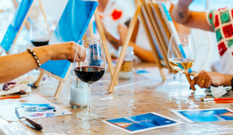 people painting while having a glass of wine
