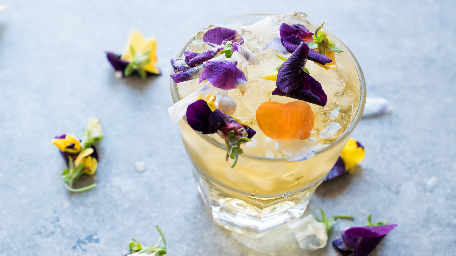 cocktail with purple and yellow flower adorning the top