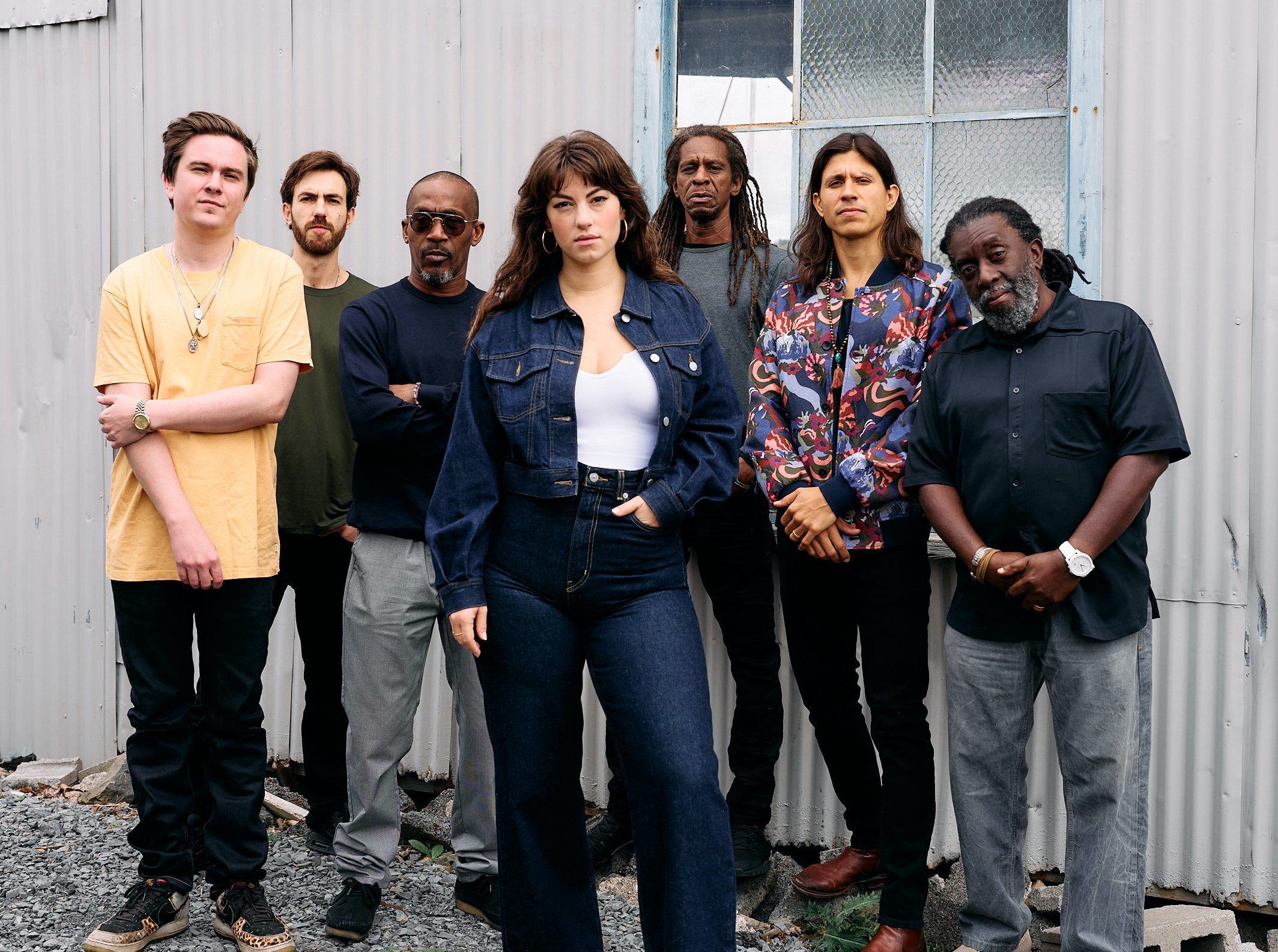 SunDub & Upstate Reggae Posse looking serious at the camera in front of a metal building