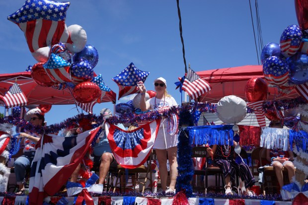WOMAN SURROUNDED BY BALLONS AT THE 4TH OF JULY PARADE
